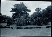 Three priests seated on a fountain, Moanalua Gardens, Oahu.